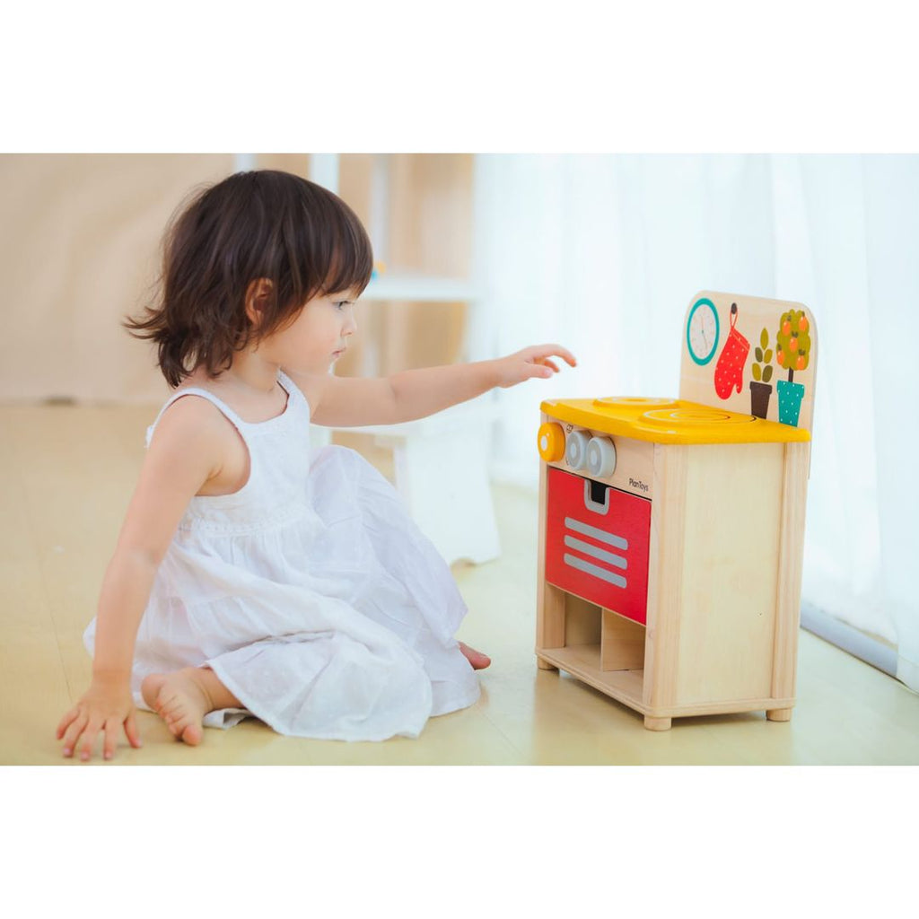 Kid playing PlanToys Kitchen Set