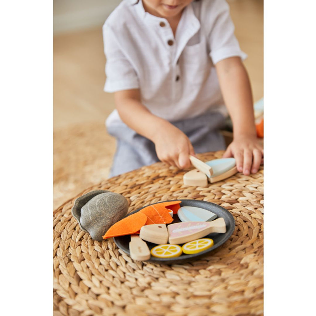 Kid playing PlanToys Seafood Platter