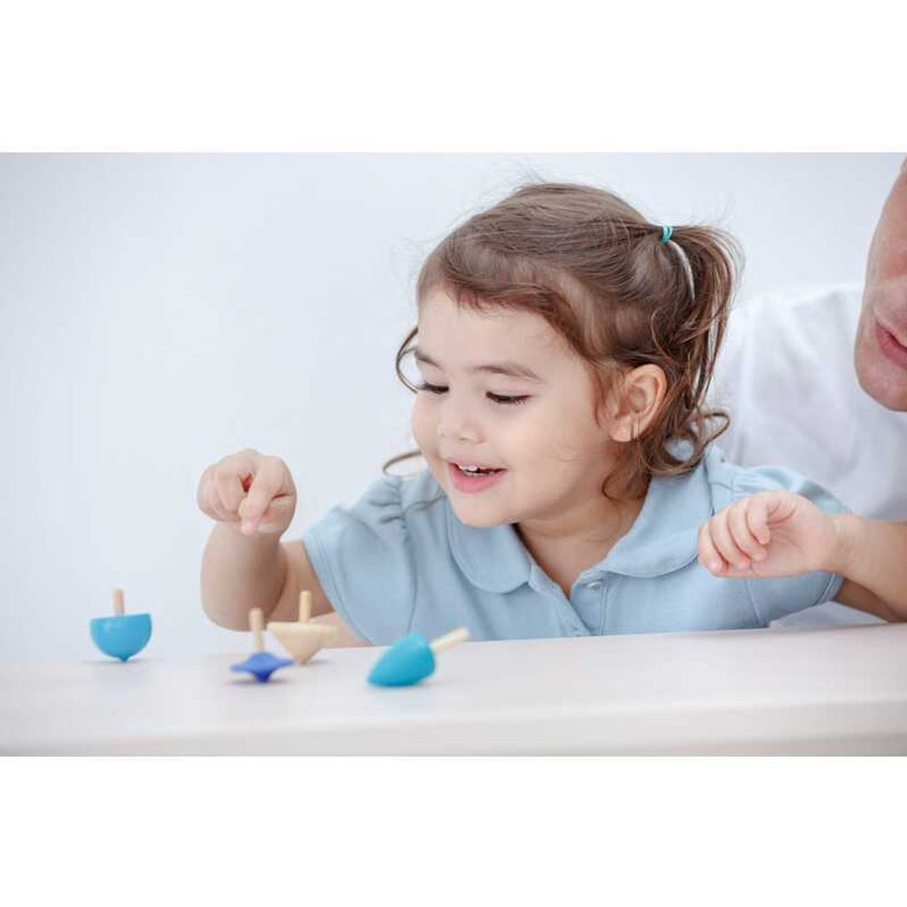 Kid playing PlanToys Spinning Tops