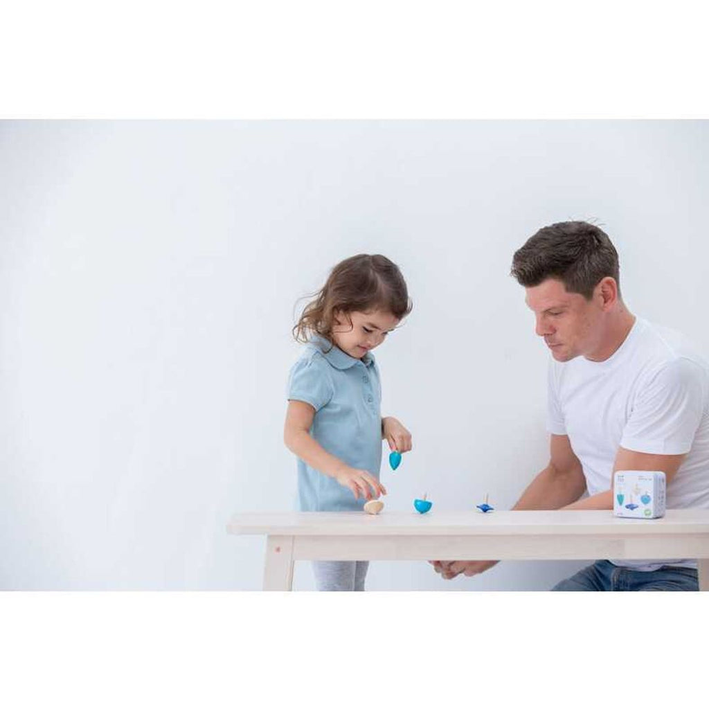 Kid playing PlanToys Spinning Tops