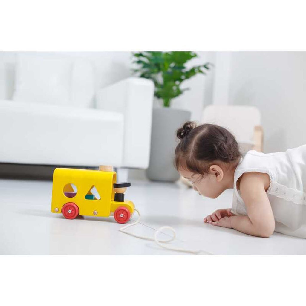 Kid playing PlanToys Sorting Bus