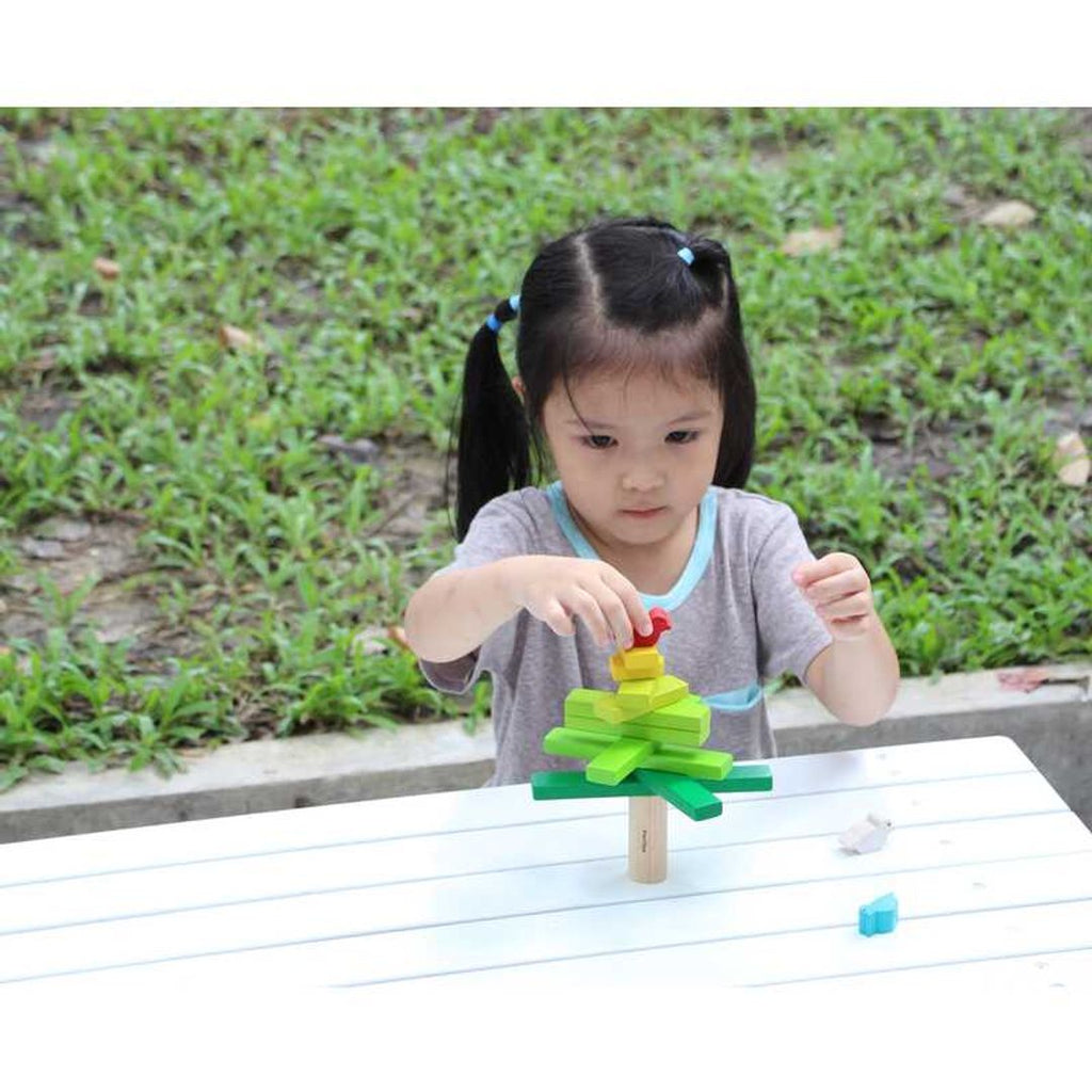 Kid playing PlanToys Balancing Tree