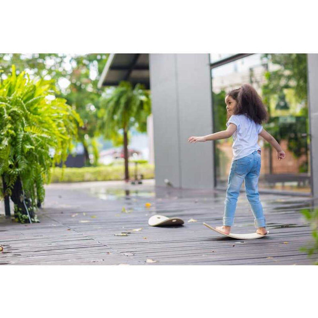 Kid playing PlanToys Balance Board