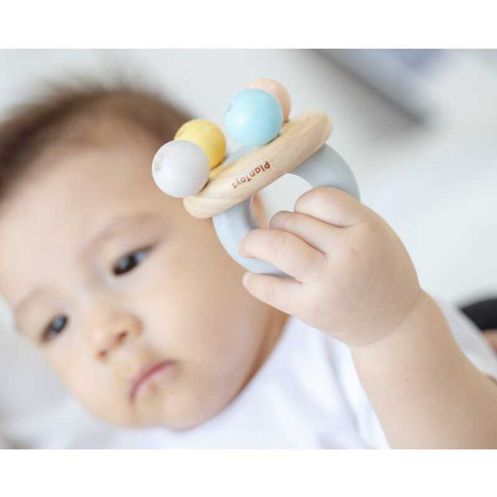 Kid playing PlanToys Bell Rattle - Pastel Series