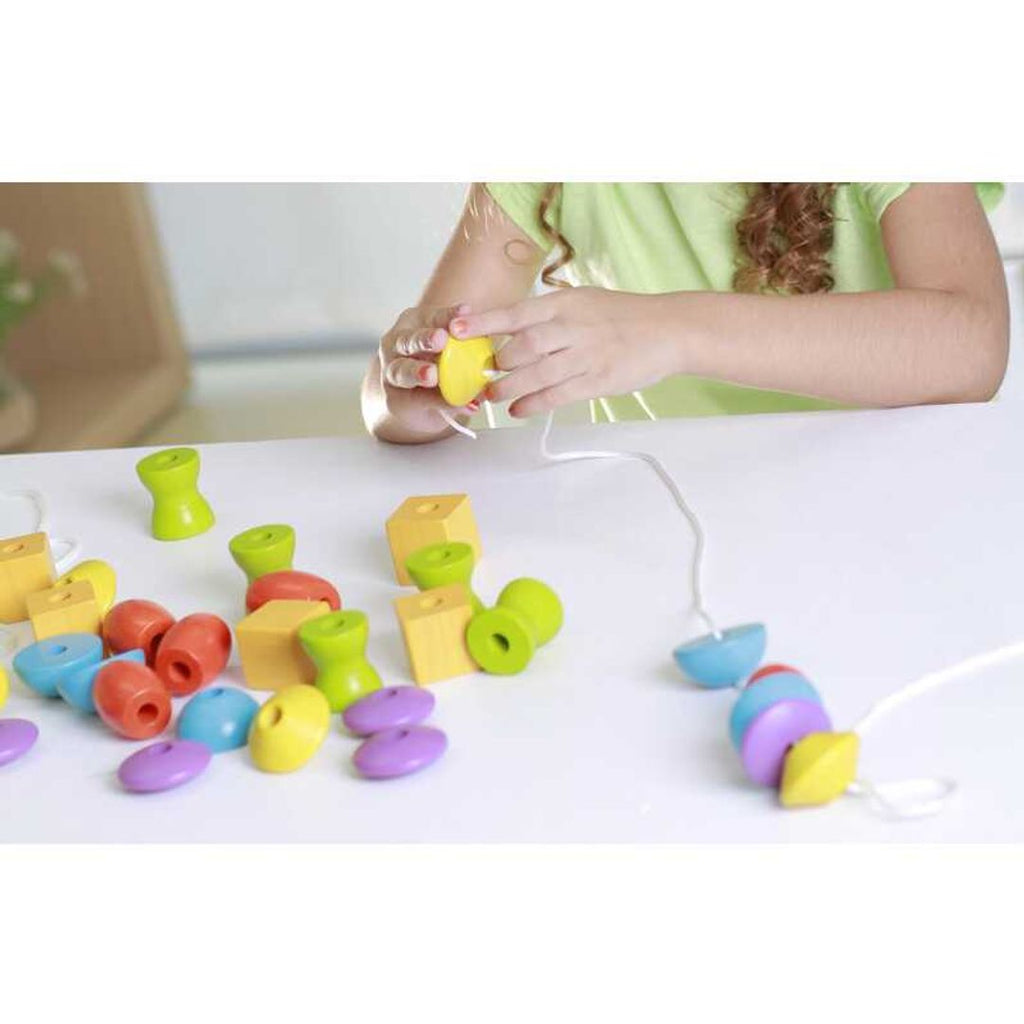 Kid playing PlanToys Lacing Beads