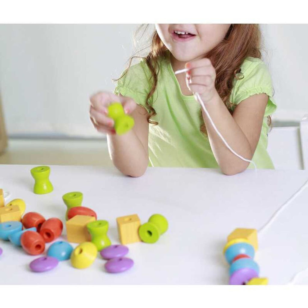 Kid playing PlanToys Lacing Beads