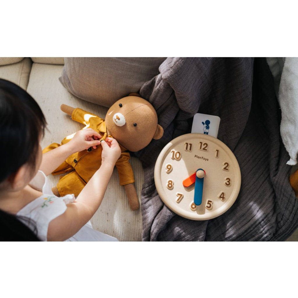 Kid playing PlanToys Activity Clock