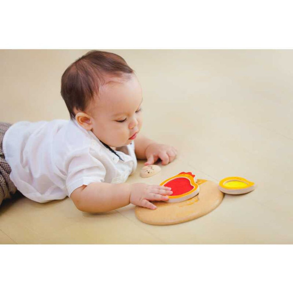 Kid playing PlanToys Chicken Puzzle