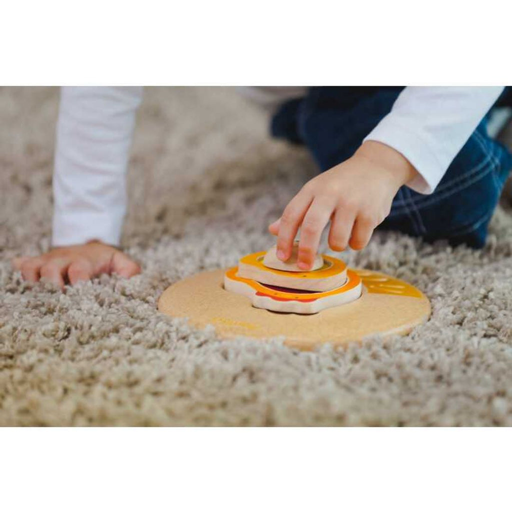 Kid playing PlanToys Chicken Puzzle