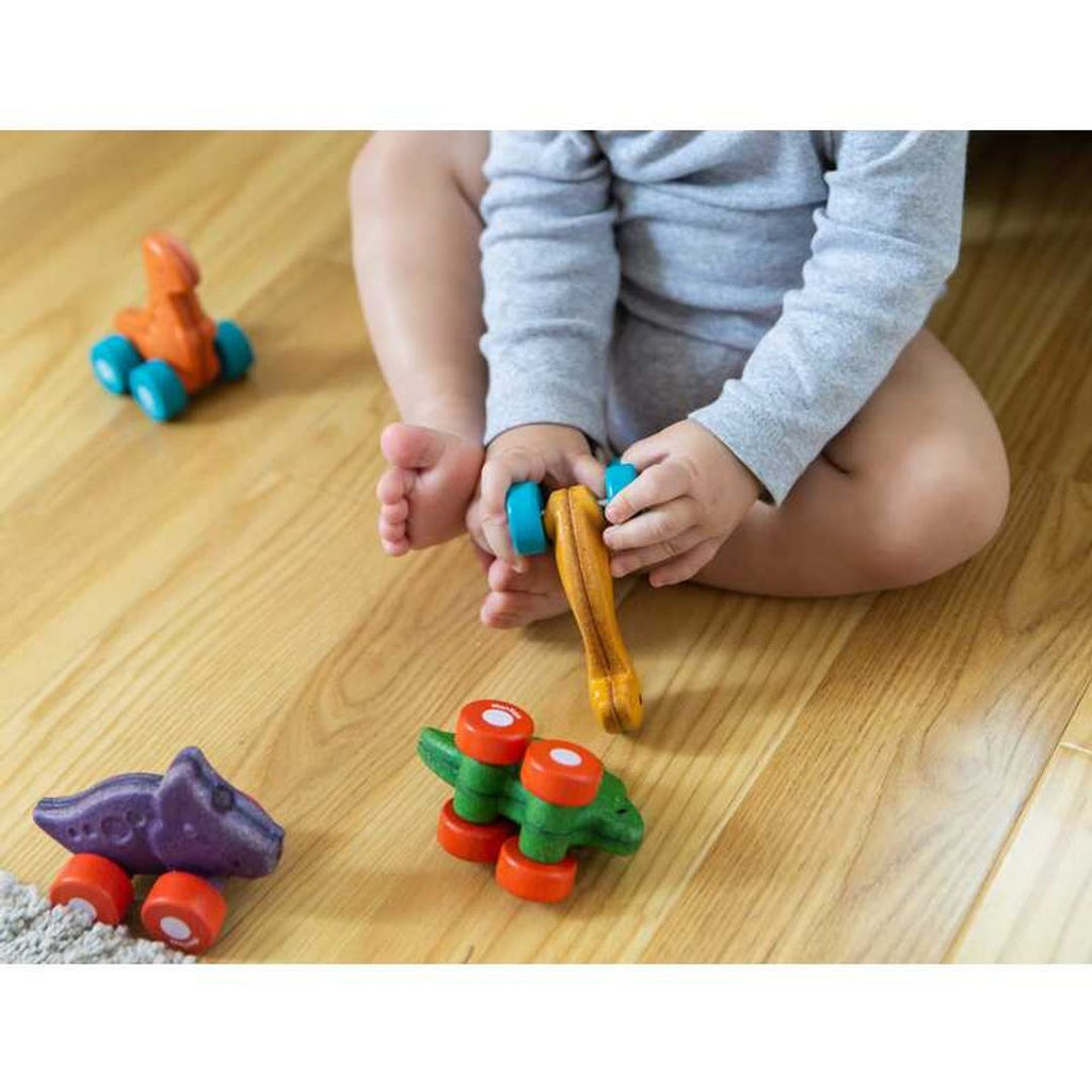 Kid playing PlanToys Dino Car - Stego