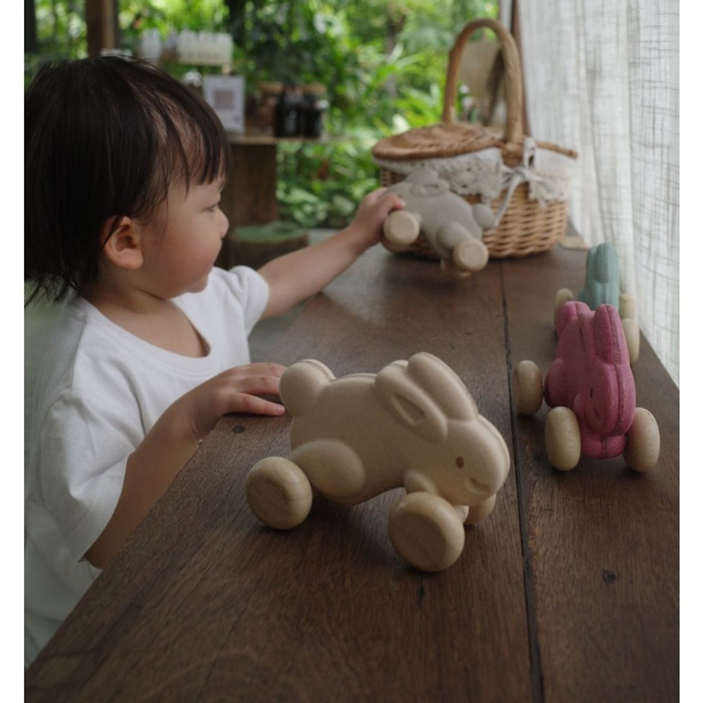 Kid playing PlanToys Push Along Bunny - Brown