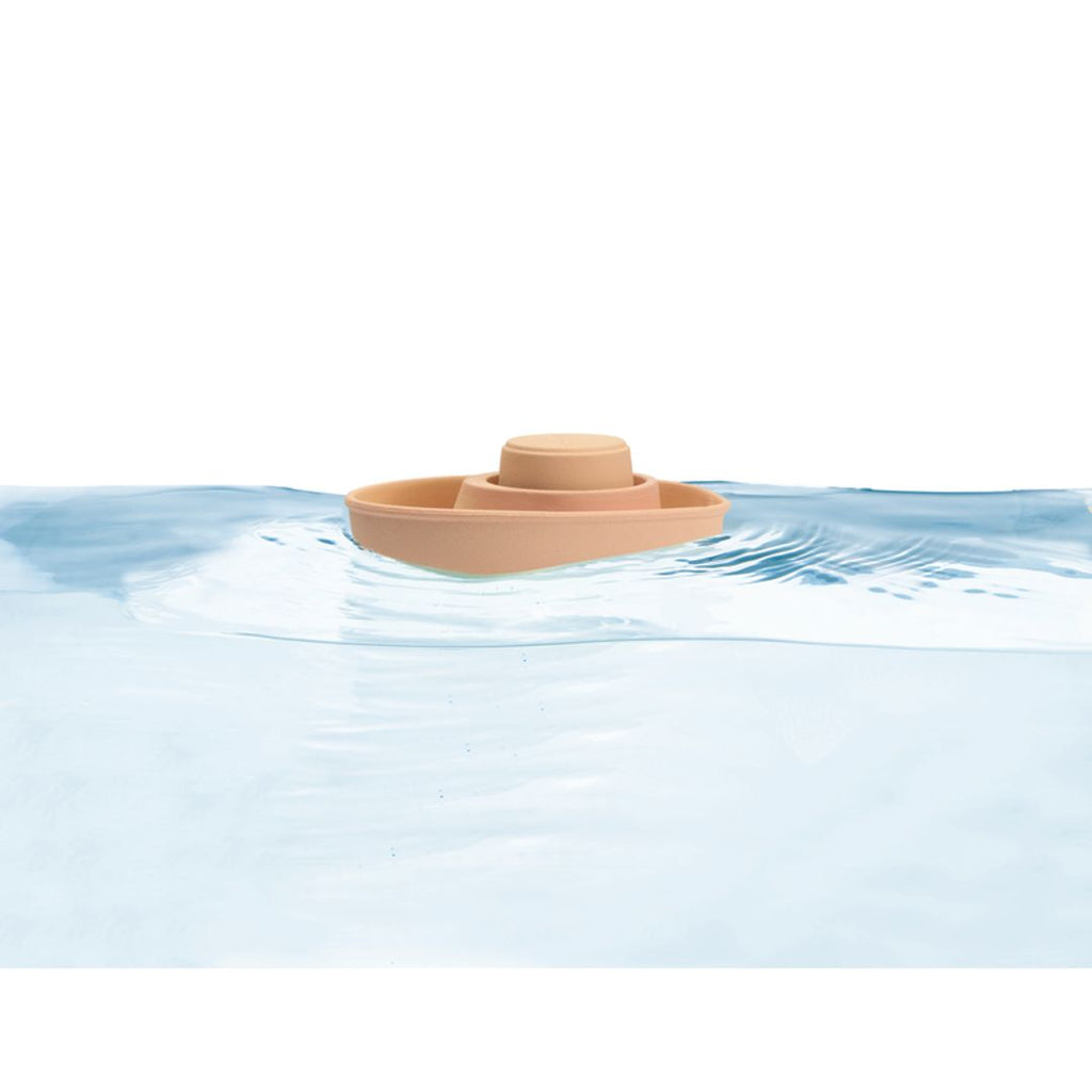 Kid playing PlanToys Rubber Convertible Boat – Pastel Orange