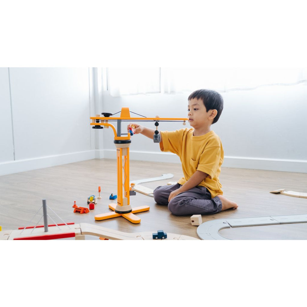 Kid playing PlanToys Crane Set