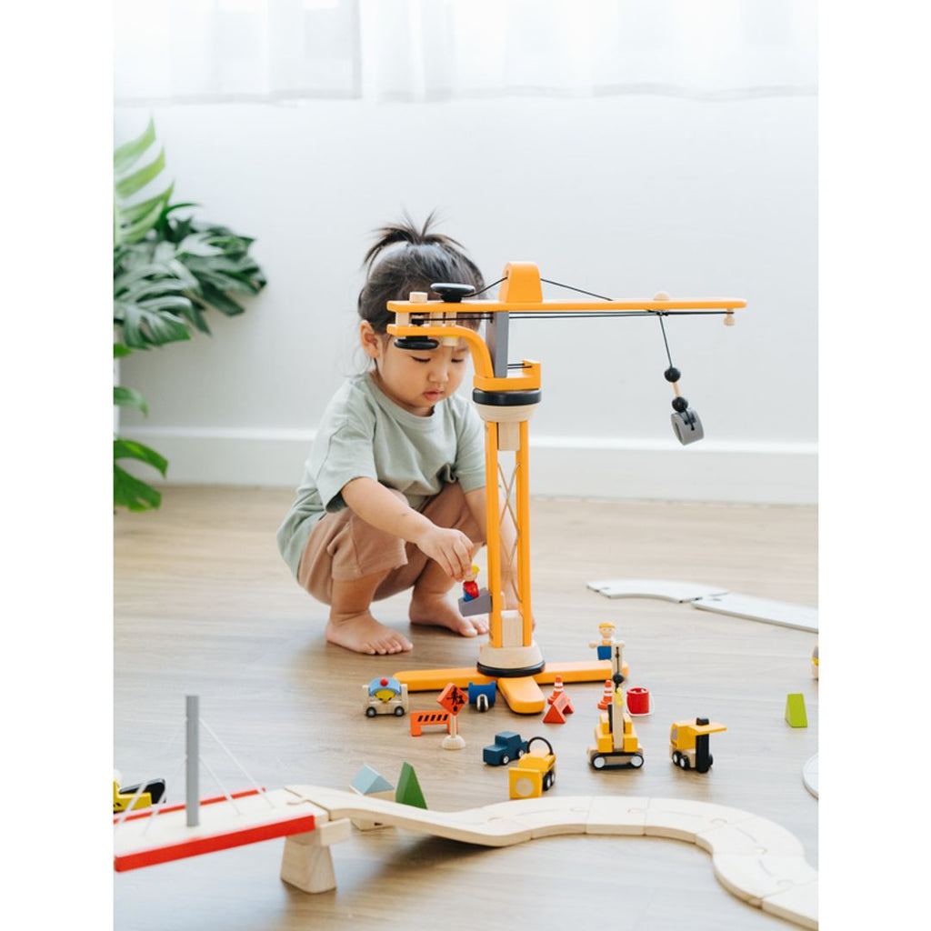 Kid playing PlanToys Crane Set