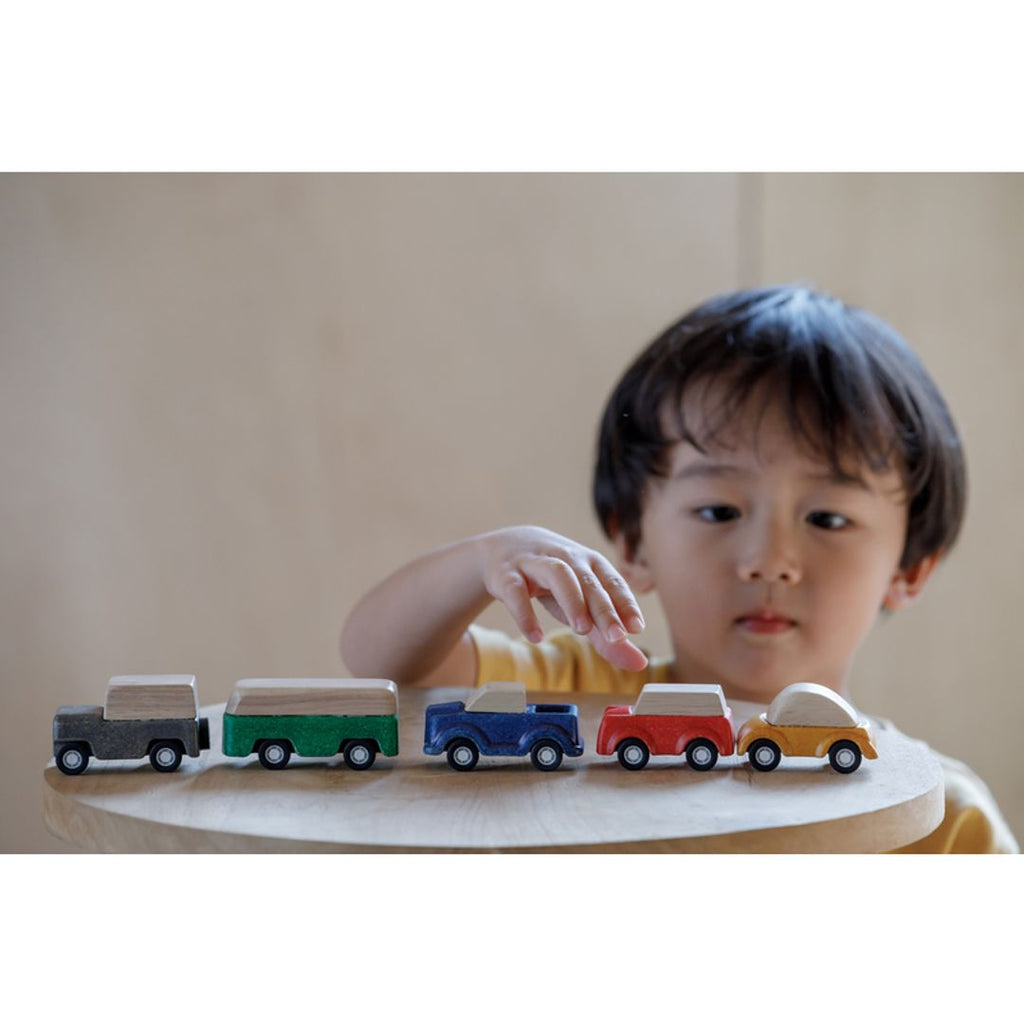 Kid playing PlanToys cars