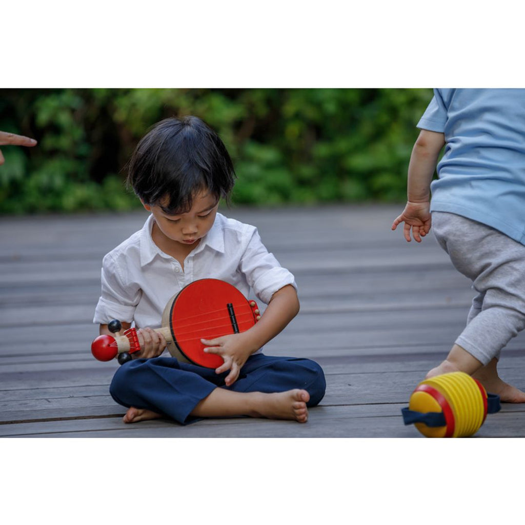 Kid playing PlanToys Banjo