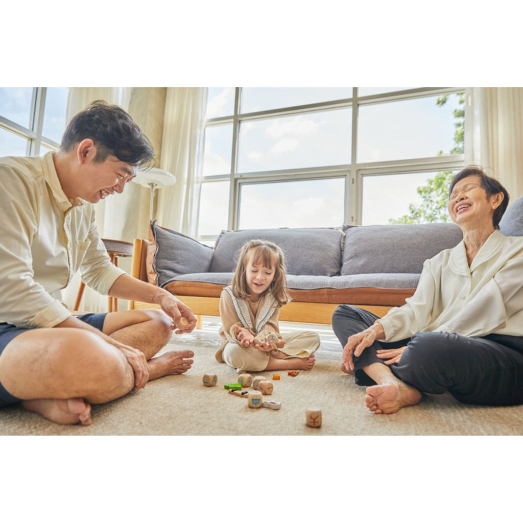 Family playing PlanToys Storytelling Dice